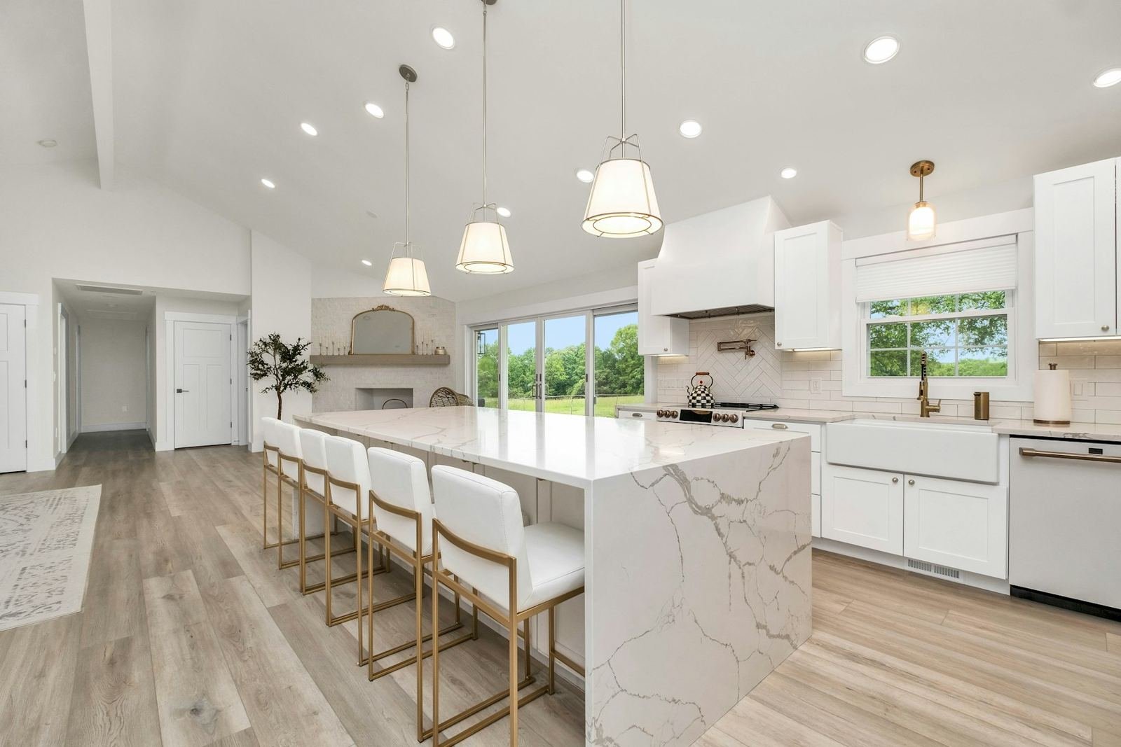 Bright remodeled kitchen with a marble island and white cabinets
