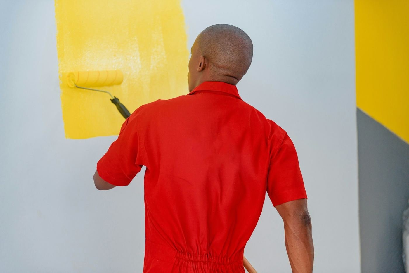 Painter rolling a bright yellow accent wall