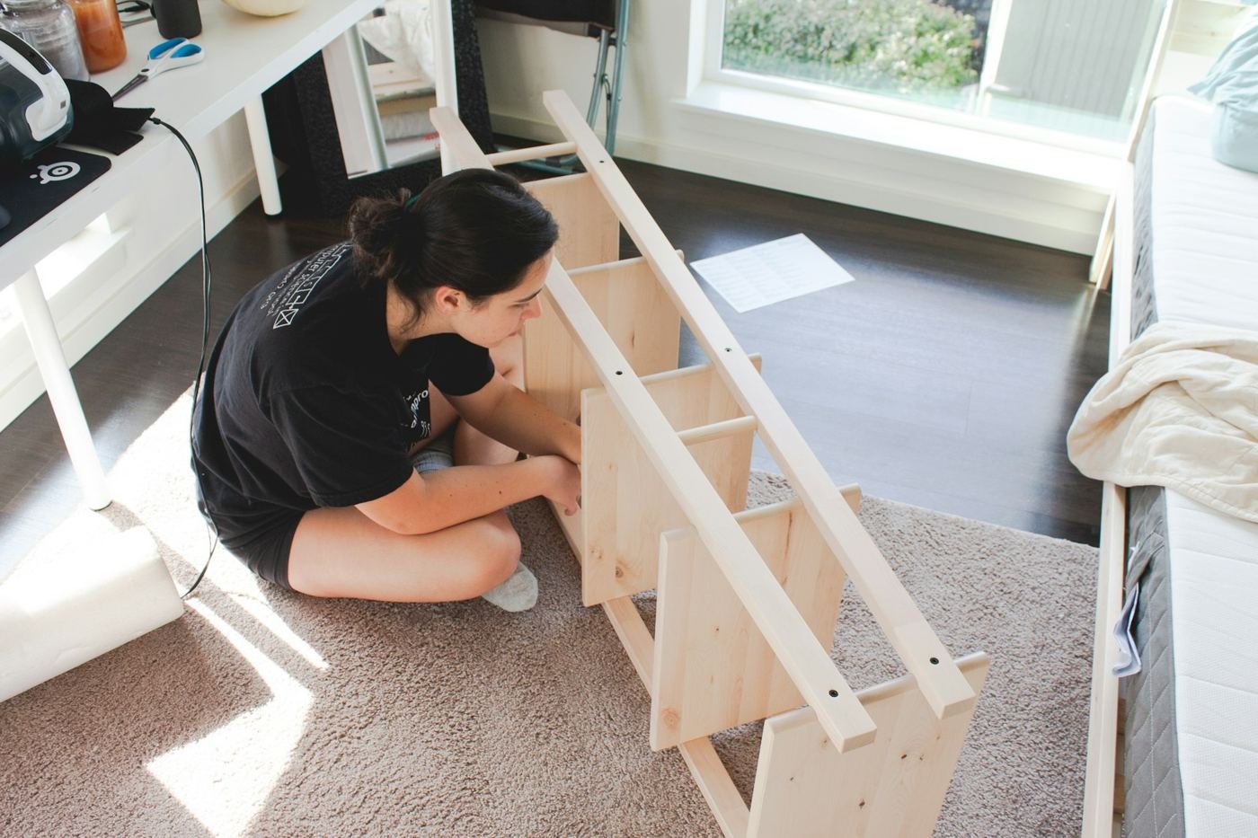 Assembling a flat-pack wooden shelf unit on a living room floor