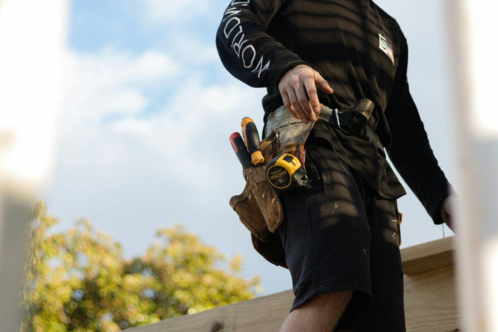 Handyman with a leather tool belt and tape measure, ready for the next job